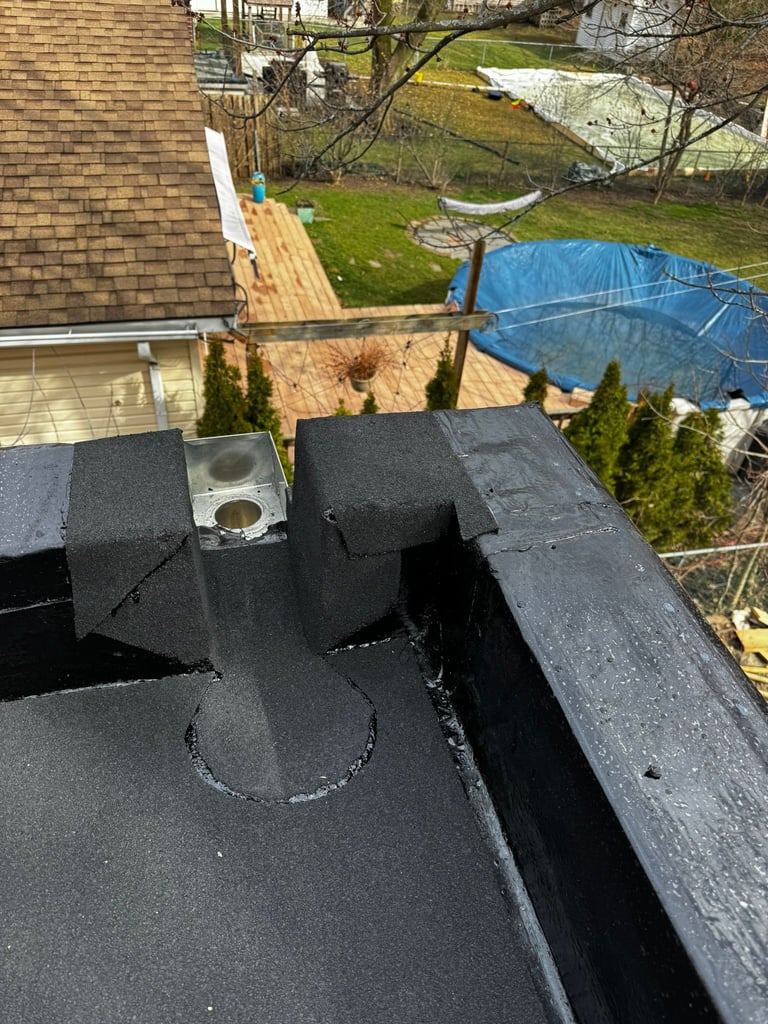 Aerial view of roof ventilation system with black ducts and vents overlooking residential backyard with tarps and lawn.