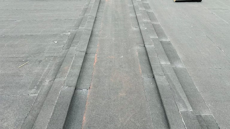 Aerial view of asphalt road with white lane markings and center red line stretching into distance